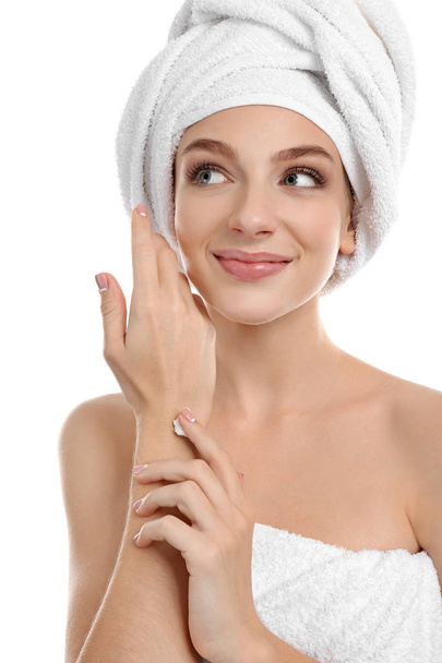 Young woman applying hand cream, on white background - Fotografie, Obrázek