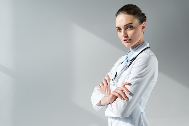 confident female doctor with crossed arms looking at camera - Foto, Imagen