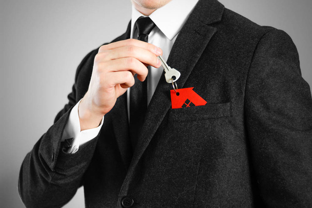 Ключи от дома у человека в черном костюме. Красное кольцо
  - Фото, изображение