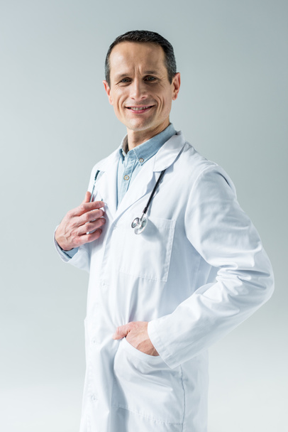 красивий дорослий лікар зі стетоскопом, який дивиться на камеру ізольовано на сірому
 - Фото, зображення