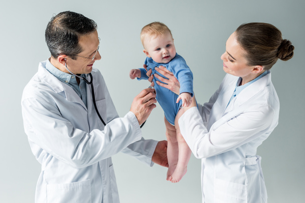 pediatricians checking breath of beautiful little baby on grey - Φωτογραφία, εικόνα