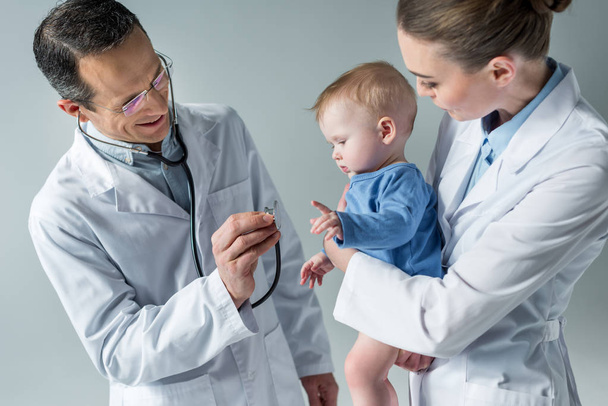 笑顔の小児科医が愛らしい赤ちゃんの息をチェック - 写真・画像