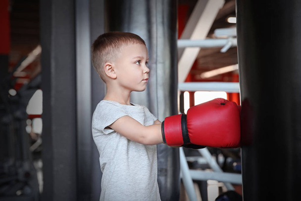 Little boy training with punchbag in boxing gym - Foto, Bild