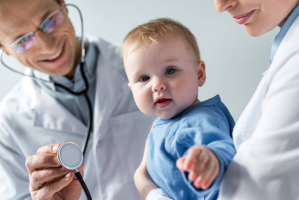 cropped shot of pediatricians checking breath of adorable little baby - Foto, immagini