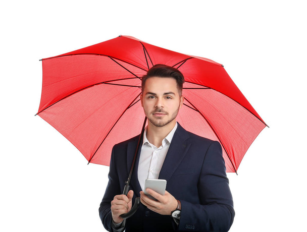 Fiatal férfi piros esernyő és smartphone fehér háttér - Fotó, kép