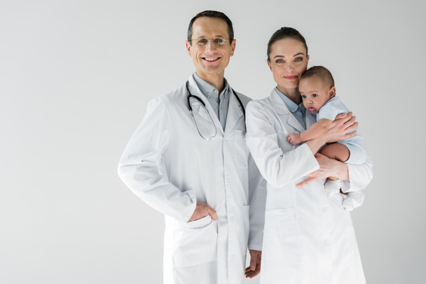 happy adult pediatricians with little baby isolated on white - Photo, Image