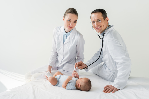 pediatri felici che ascoltano il respiro del piccolo bambino con stetoscopio
 - Foto, immagini