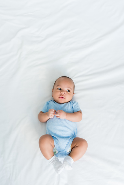top view of adorable little child lying on bed - Fotografie, Obrázek