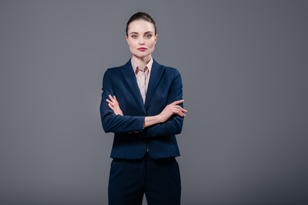 serious adult businesswoman with crossed arms looking at camera isolated on grey - Foto, immagini