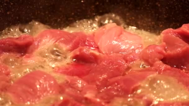 Vlees met een hoog vochtgehalte is gebakken in een koekenpan en stoot daarbij een heleboel water - Video