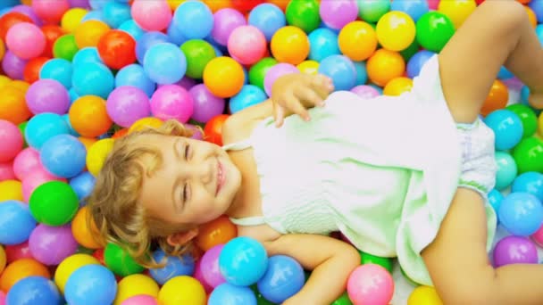 Lachen kleines Mädchen spielt Plastikbälle - Filmmaterial, Video