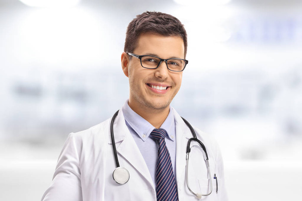 Close-up of a young doctor looking at the camera and smiling - Foto, imagen