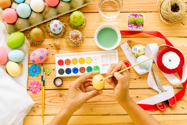 ¡Feliz Pascua! Una mujer pintando huevos de Pascua
.  - Foto, imagen
