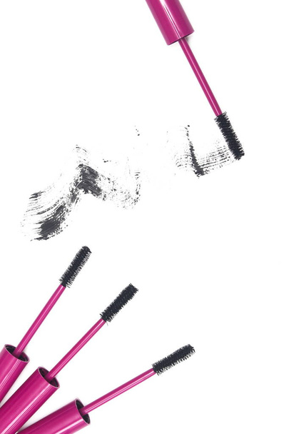 Mascara wands in roze en mascara penseelstreek op witte achtergrond. - Foto, afbeelding