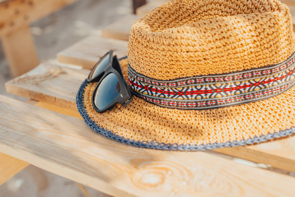 солнцезащитные очки лежат и шляпный шезлонг на пляже в солнечный день. Ура! наконец-то отдохнуть
 - Фото, изображение