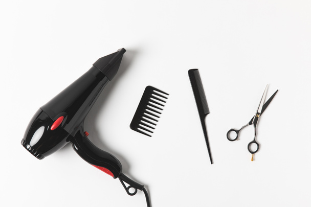 top view of hair dryer, combs and scissors, on white - Foto, Imagen