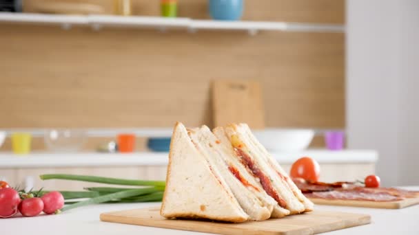 Four club sandwiches lying on wooden board - Footage, Video