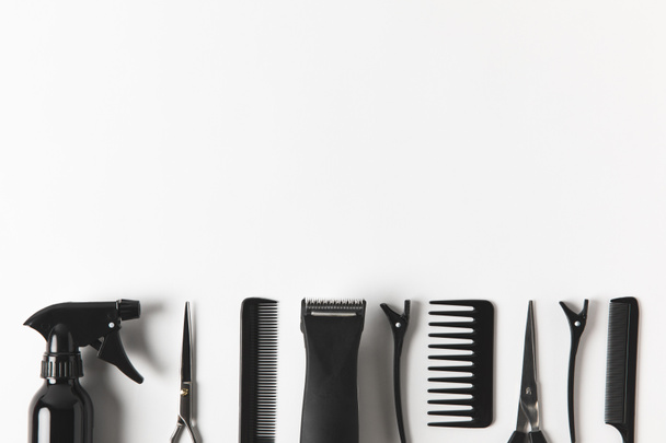 Draufsicht auf Haarschneidemaschine und Friseurwerkzeuge in Reihe, auf weiß - Foto, Bild
