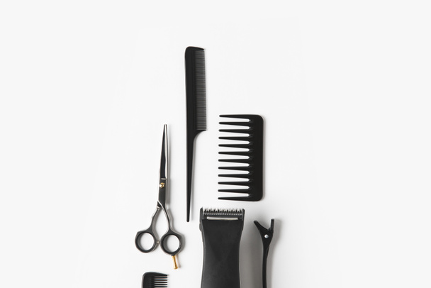 flache Lage mit Haarmaschine und Friseurwerkzeugen, auf weißem - Foto, Bild