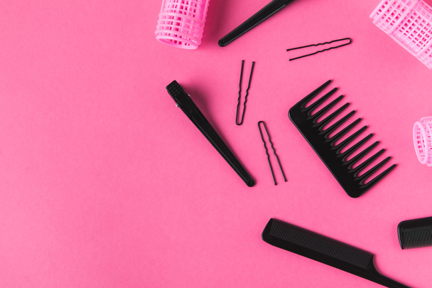flat lay with curlers and hairdressing tools, on pink - Foto, afbeelding