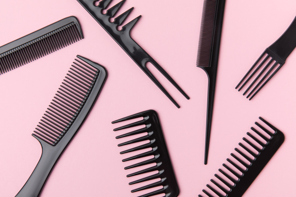 top view of black combs, isolated on light pink - Foto, Imagem