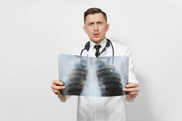 Homme médecin concentré perplexe avec rayons X des poumons, fluorographie, roentgen isolé sur fond blanc. Médecin en uniforme médical, stéthoscope. Personnel de santé, concept de médecine. Pneumonie
. - Photo, image