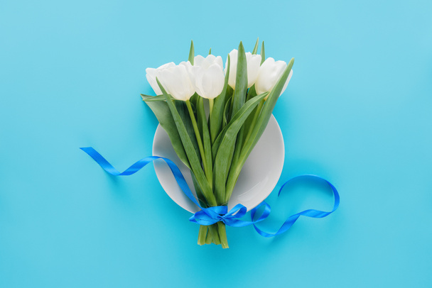 Vue de dessus des tulipes blanches sur plaque isolée sur bleu
 - Photo, image