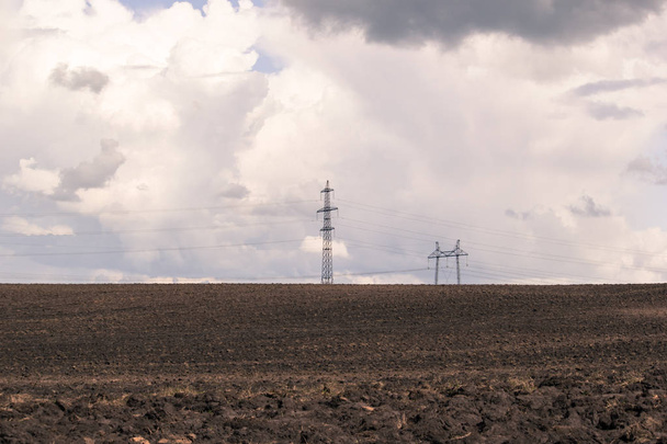 Ploughed field and power lines on the horizon - Fotoğraf, Görsel