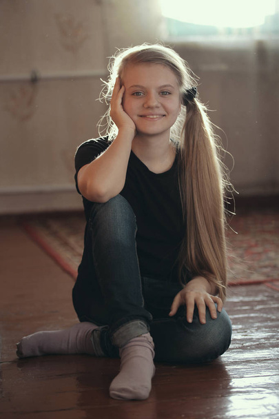 Söpö blondi tyttö teini poseeraa sittng lattialla
 - Valokuva, kuva