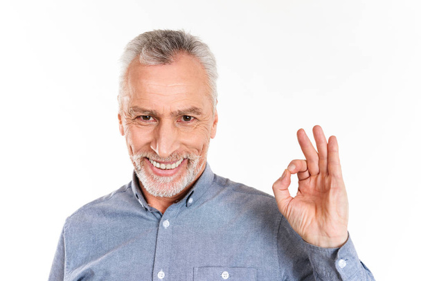 Homme heureux montrant un geste correct et souriant isolé sur blanc
 - Photo, image
