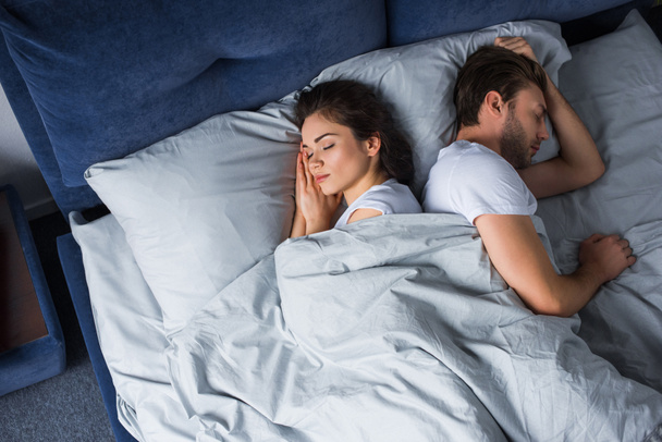 Young couple sleeping in bed in modern bedroom - Foto, imagen