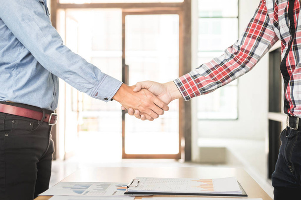 Два уверенных бизнесмена пожимают друг другу руки во время встречи в
 - Фото, изображение