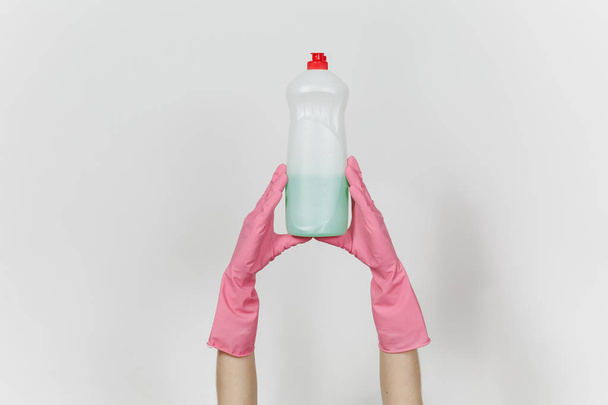 テキストは、白い背景で隔離のための場所に食器洗いグリーン クリーナー液でピンクの手袋保持している白いボトルで女性の手のクローズ アップ。クリーニング用品の概念。広告のためのスペースをコピーします。 - 写真・画像