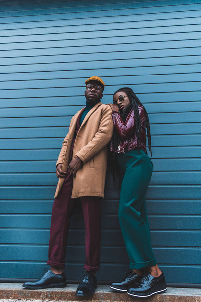 vue à angle bas du couple afro-américain élégant regardant la caméra tout en posant ensemble sur la rue
 - Photo, image