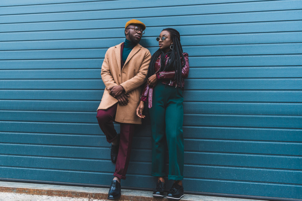 full length view of stylish african american couple in jacket and overcoat posing together on street - Foto, Imagen