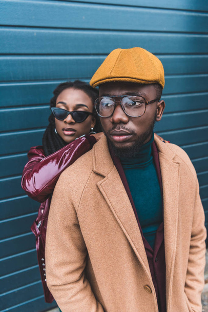 fashionable young african american couple in jacket and overcoat posing together outside  - Photo, Image