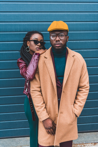 stijlvolle jonge Afrikaanse Amerikaanse echtpaar camera kijken terwijl poseren samen op straat - Foto, afbeelding