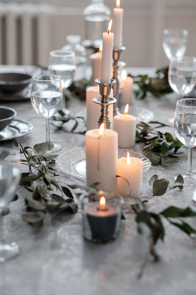 Wedding or festive table setting. Plates, wine glasses, candles and cutlery - Фото, изображение