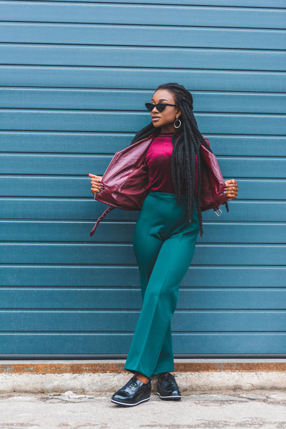 beautiful young african american woman in sunglasses posing on street - Fotó, kép