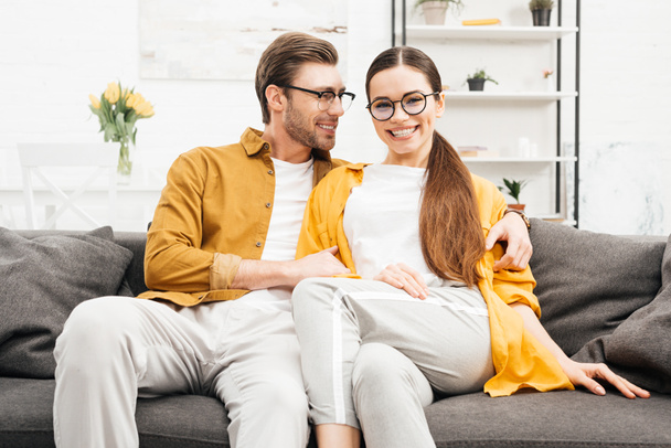 young smiling couple relaxing on comfy couch at home - Photo, Image