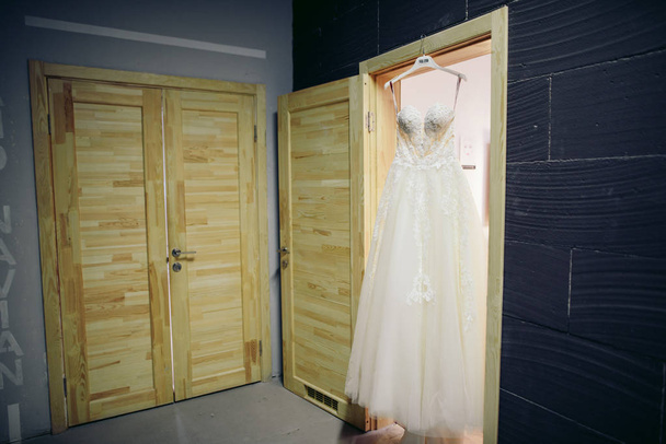 Klassieke witte trouwjurk, opknoping op een deur - Foto, afbeelding