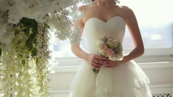 Atrakcyjny model w sukni ślubnej z narzeczonych bukiet - Materiał filmowy, wideo