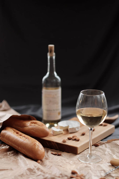 A glass of white wine and cheese on a blackboard - Φωτογραφία, εικόνα