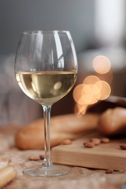 A glass of white wine and cheese on a blackboard - Фото, зображення