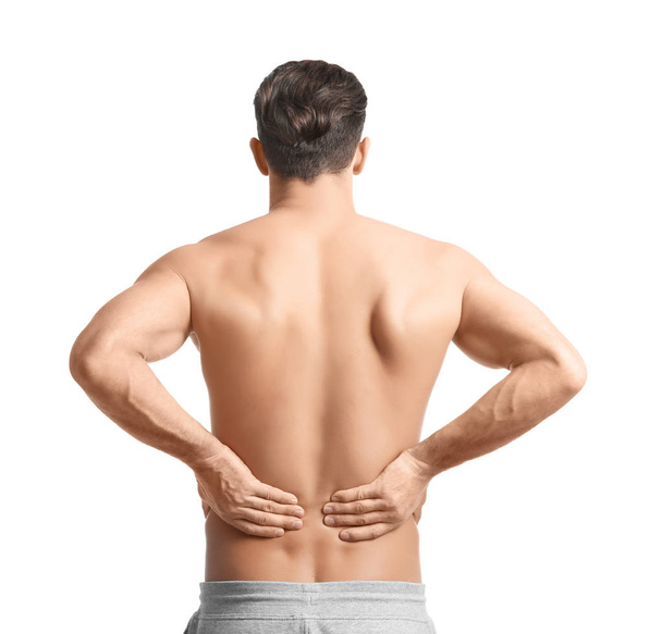 Young man suffering from back pain on white background - Фото, зображення