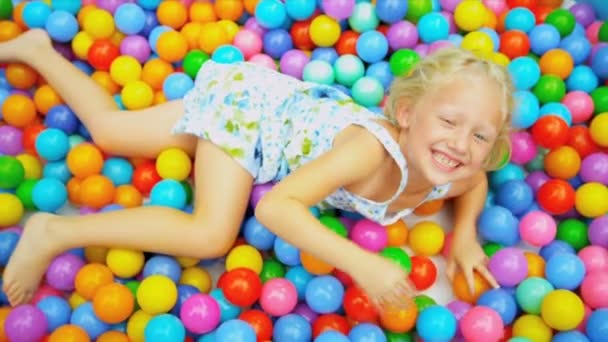 roztomilá blondýnka dítě těší míč bazén - Záběry, video