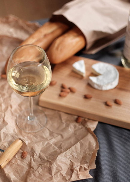 A glass of white wine and cheese on a blackboard - Fotoğraf, Görsel