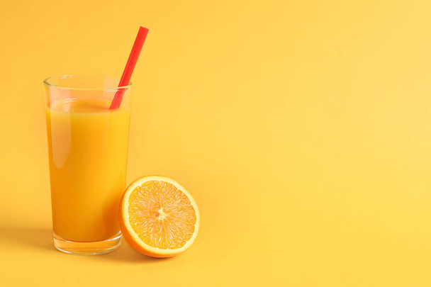Glass of orange juice with fresh fruit on color background - Φωτογραφία, εικόνα