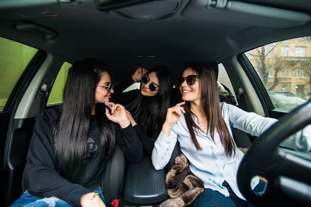 Três mulheres no carro. Meninas podem dirigir o carro através da cidade
 - Foto, Imagem