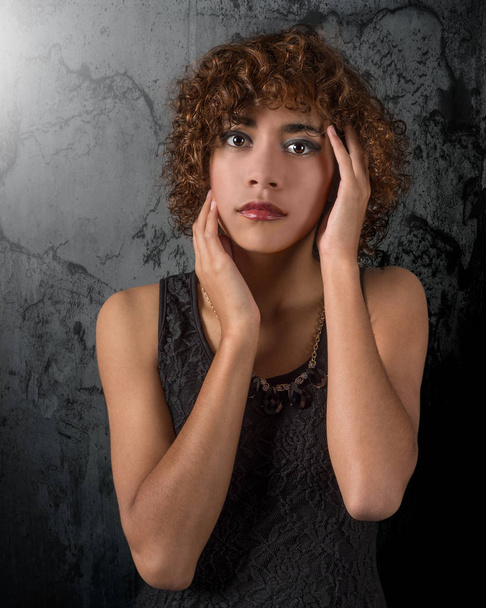 Mujer joven de raza mixta hermosa etérea con ojos increíbles y cabello rizado contra un fondo grunge
 - Foto, imagen